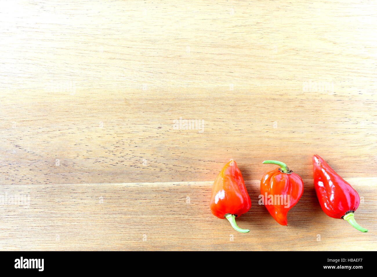 Red Chili Peppers ghost sur une planche en bois Banque D'Images