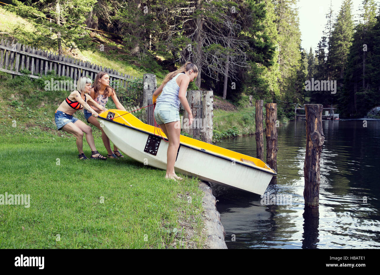 Trois amis femelles adultes lancement d'aviron dans le lac, Sattelbergalm, Tirol, Autriche Banque D'Images