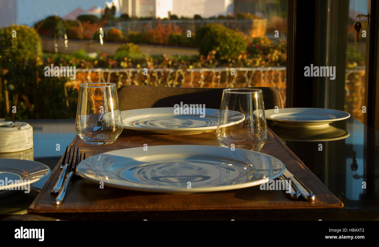 Table au restaurant servi pour 2 personnes avec des verres, assiettes Photo  Stock - Alamy