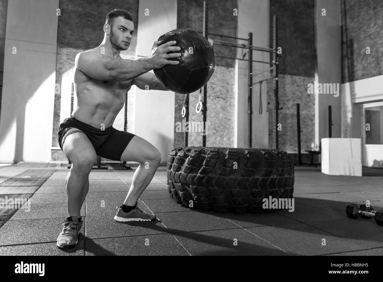 Bel homme musclé s'entraîner avec un ballon Banque D'Images