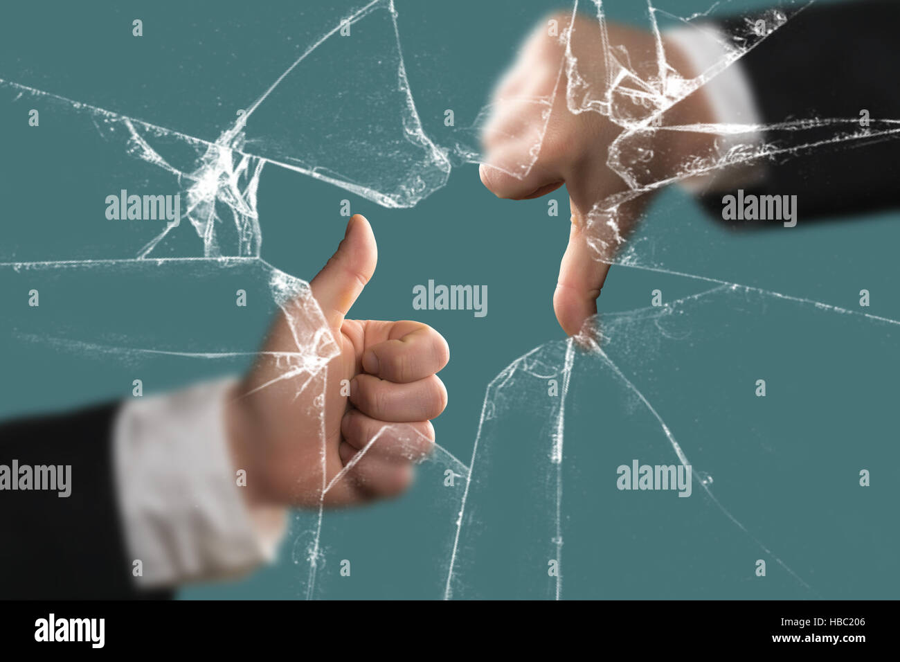 Pouce vers le bas et vers le haut derrière une vitre cassée Banque D'Images