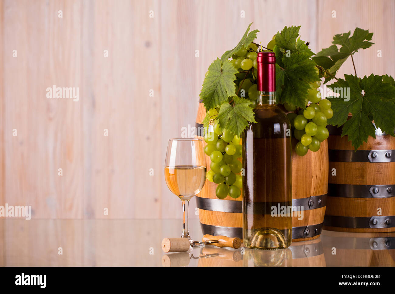 Bouteille de vin blanc avec des raisins et des barils grapeleaves sur verre Banque D'Images