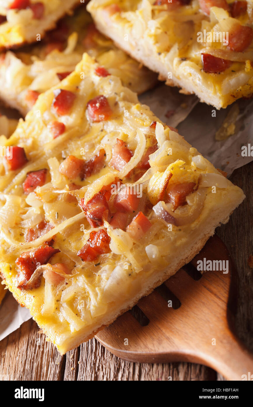 Accueil tarte fraîchement cuits au four avec des oignons, du bacon close-up sur la table verticale. Banque D'Images