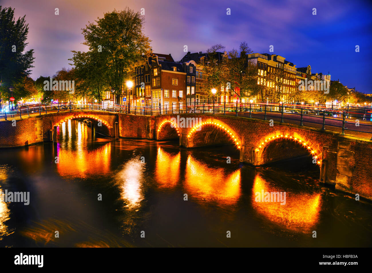 Vue sur la ville d'Amsterdam avec ses canaux et ses ponts la nuit Banque D'Images