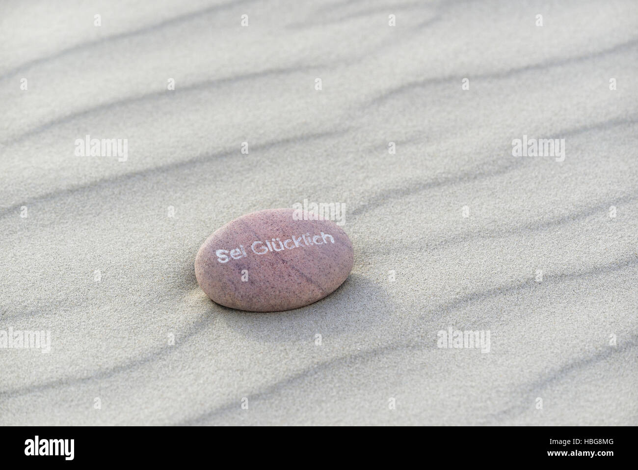 Être heureux inscrit dans petite pierre, plage de sable, îles de la Frise orientale, Basse-Saxe, Allemagne Banque D'Images