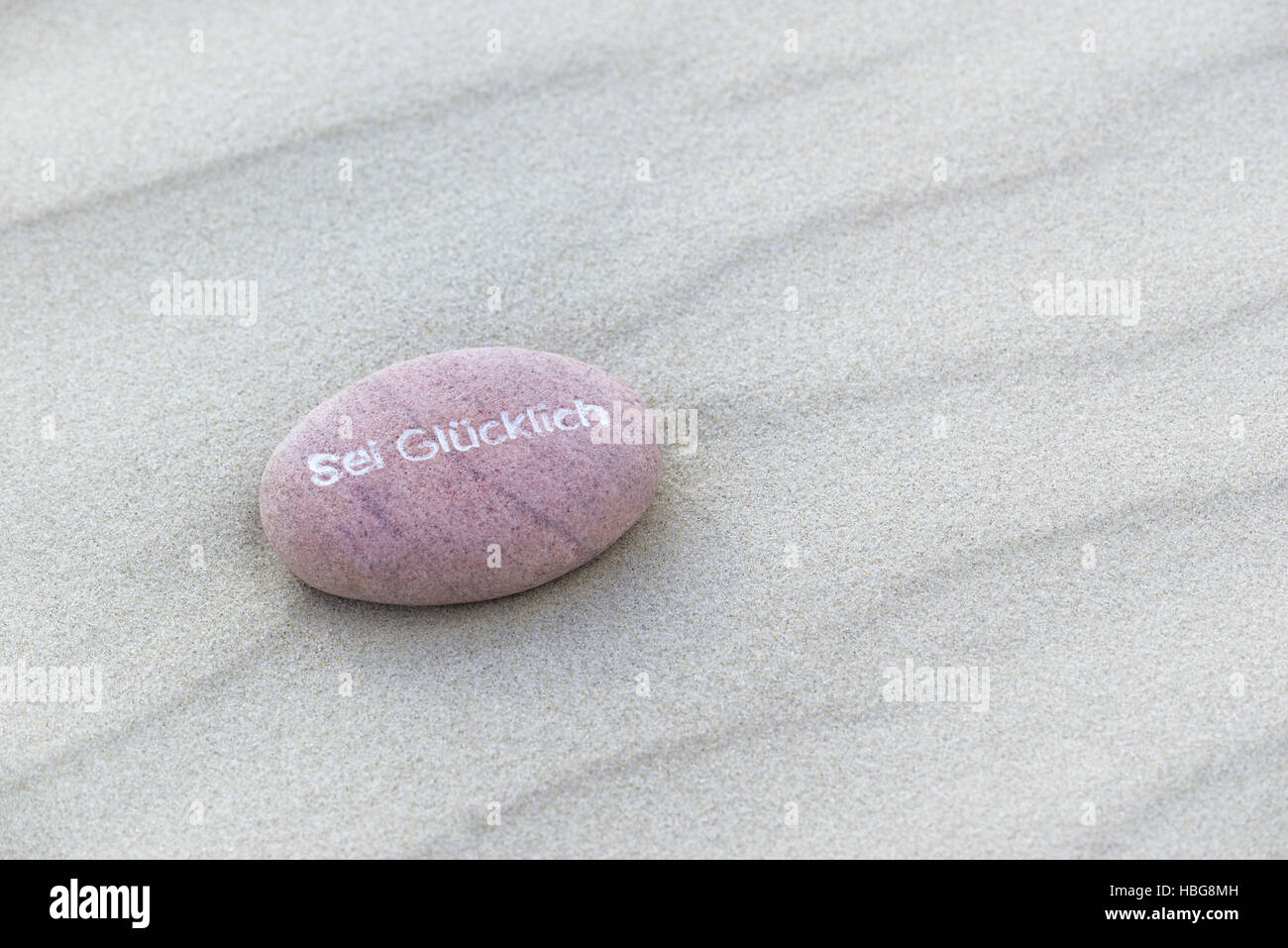 Être heureux inscrit dans petite pierre, plage de sable, îles de la Frise orientale, Basse-Saxe, Allemagne Banque D'Images