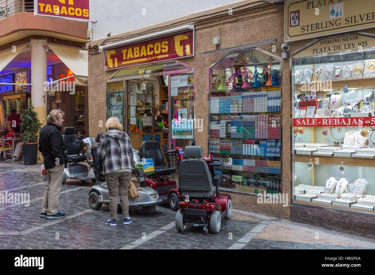 Quatre scooters handicap stationné à l'extérieur d'un magasin de tabac dans la vieille ville de Benidorm Banque D'Images