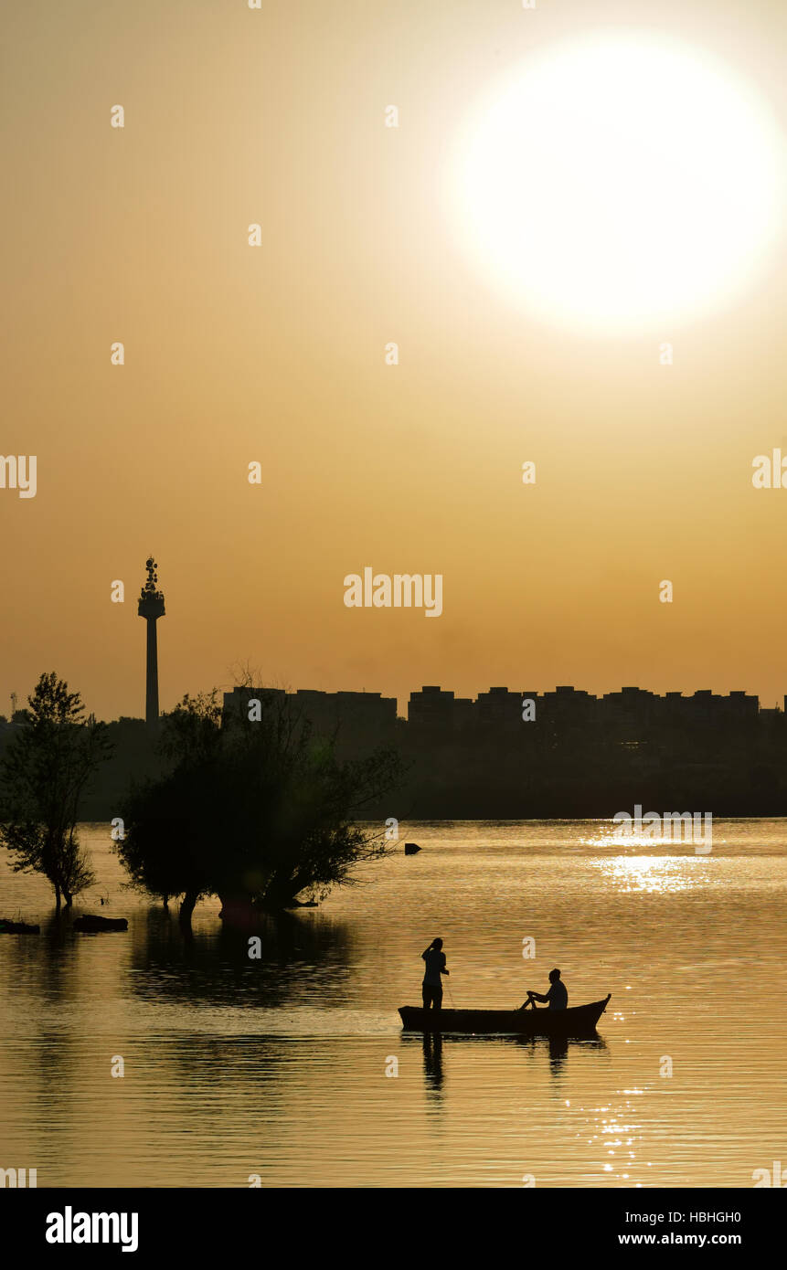 Silhouette de pêcheurs avec orange et soleil sur Danube Banque D'Images