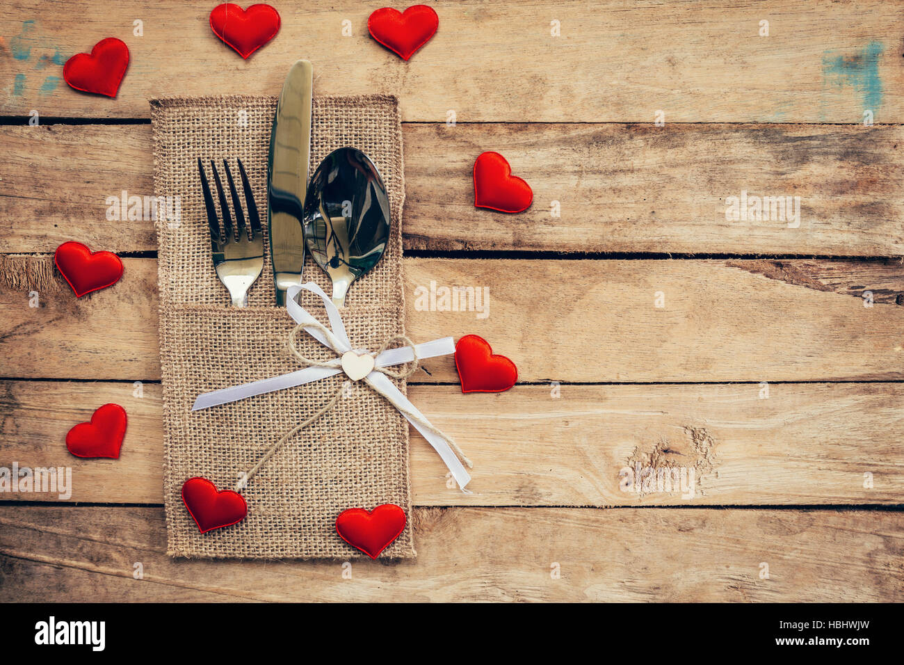 Set de table pour la célébration de la Saint-Valentin. Table en bois couvert et de l'argenterie avec coeur rouge pour la Saint-Valentin. Banque D'Images