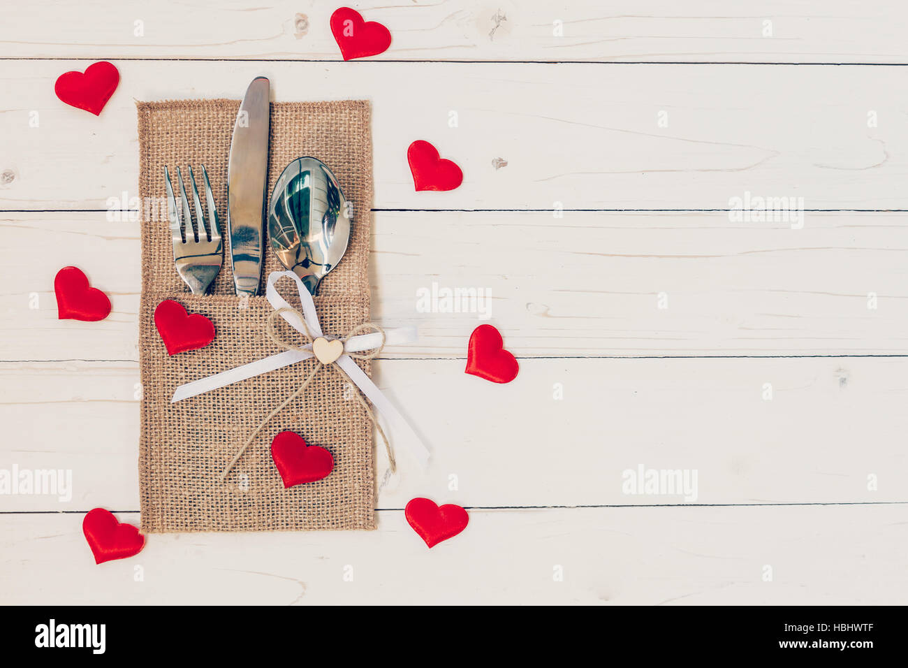 Set de table pour la célébration de la Saint-Valentin. Table en bois couvert et de l'argenterie avec coeur rouge pour la Saint-Valentin. Banque D'Images