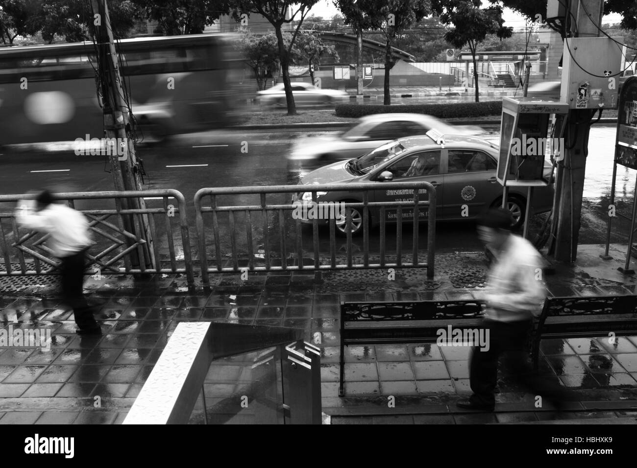 Les gens courent à partir de la pluie sur un trottoir à Bangkok, Thaïlande. Banque D'Images