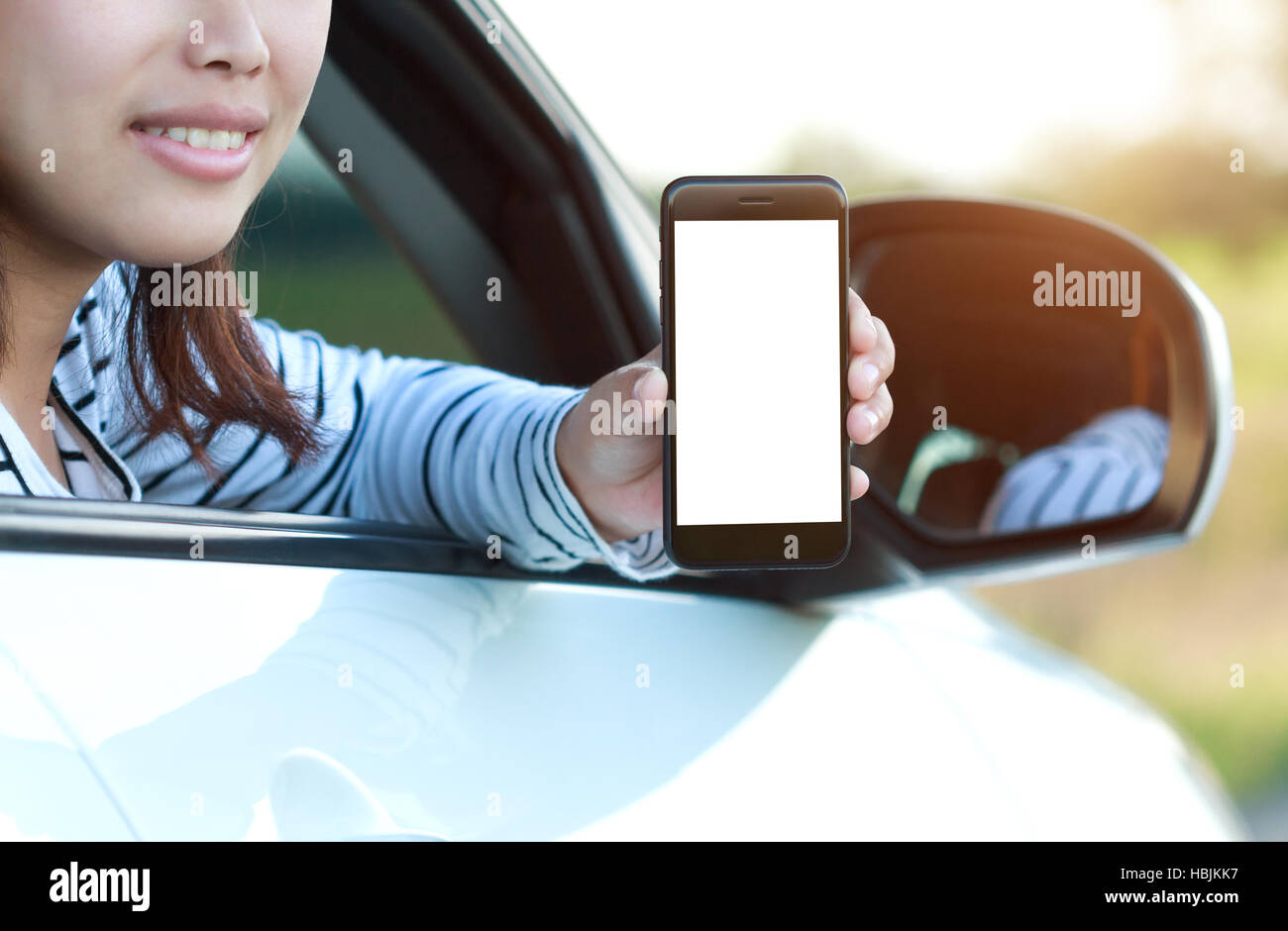 Close-up téléphone en main femme montrant écran blanc sitting in car Banque D'Images