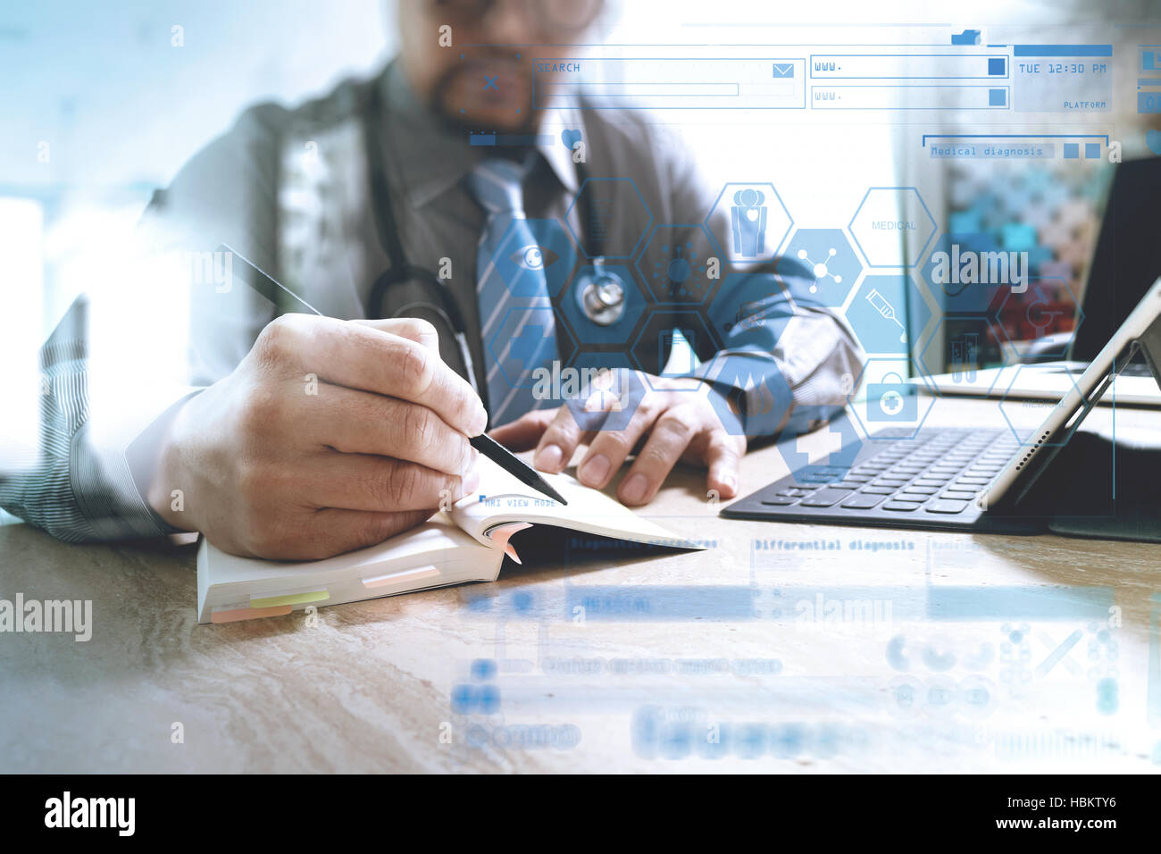 Médecin écrit sur ordinateur portable et tablette avec clavier numérique d'ordinateur portable sur le bureau en marbre,effet sun flare Banque D'Images