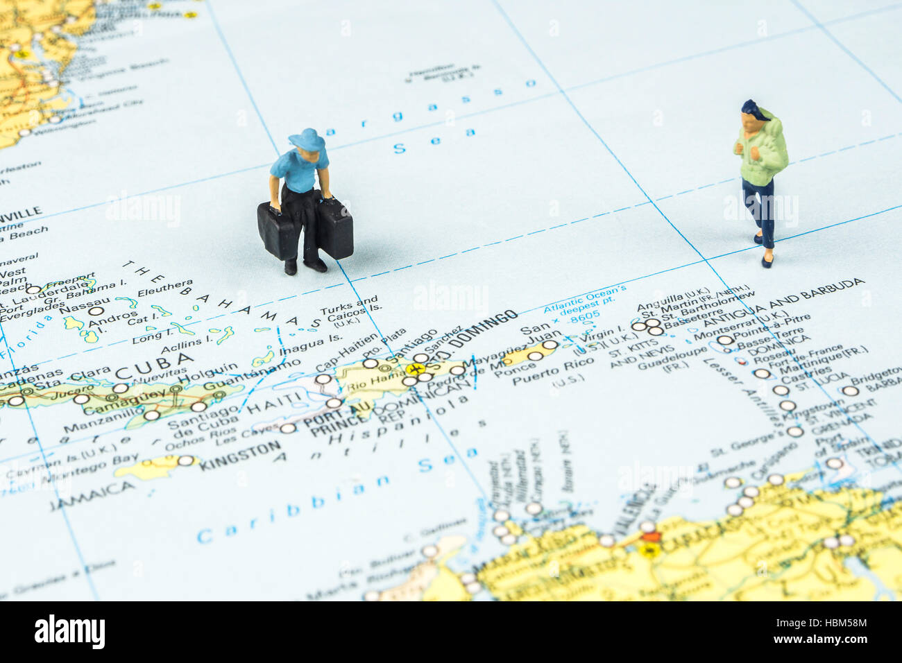 Libre de figurine miniature de jeunes voyageurs debout sur une grande carte à côté d'îles des Caraïbes Banque D'Images