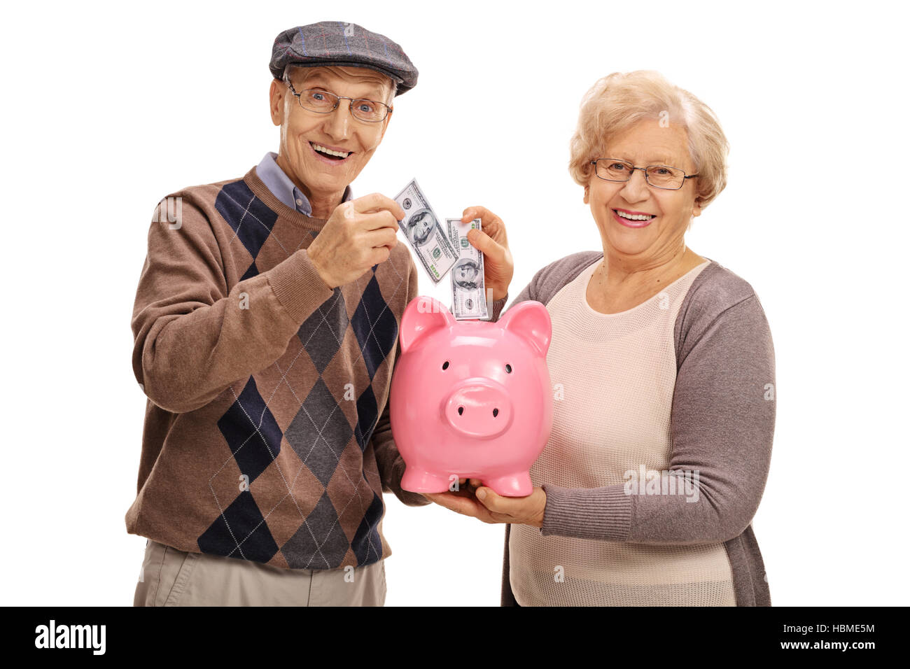 Les personnes âgées mettant l'argent dans une tirelire isolé sur fond blanc Banque D'Images
