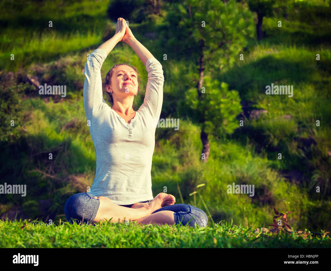 Young fit woman doing yoga Lotus poser oudoors Banque D'Images
