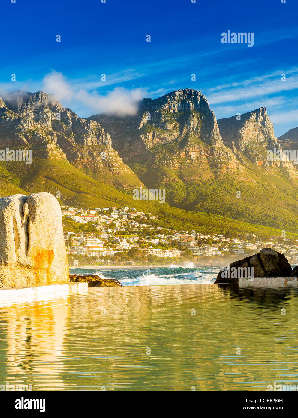 Camps Bay Ocean piscine au coucher du soleil avec la ville et les montagnes derrière Banque D'Images