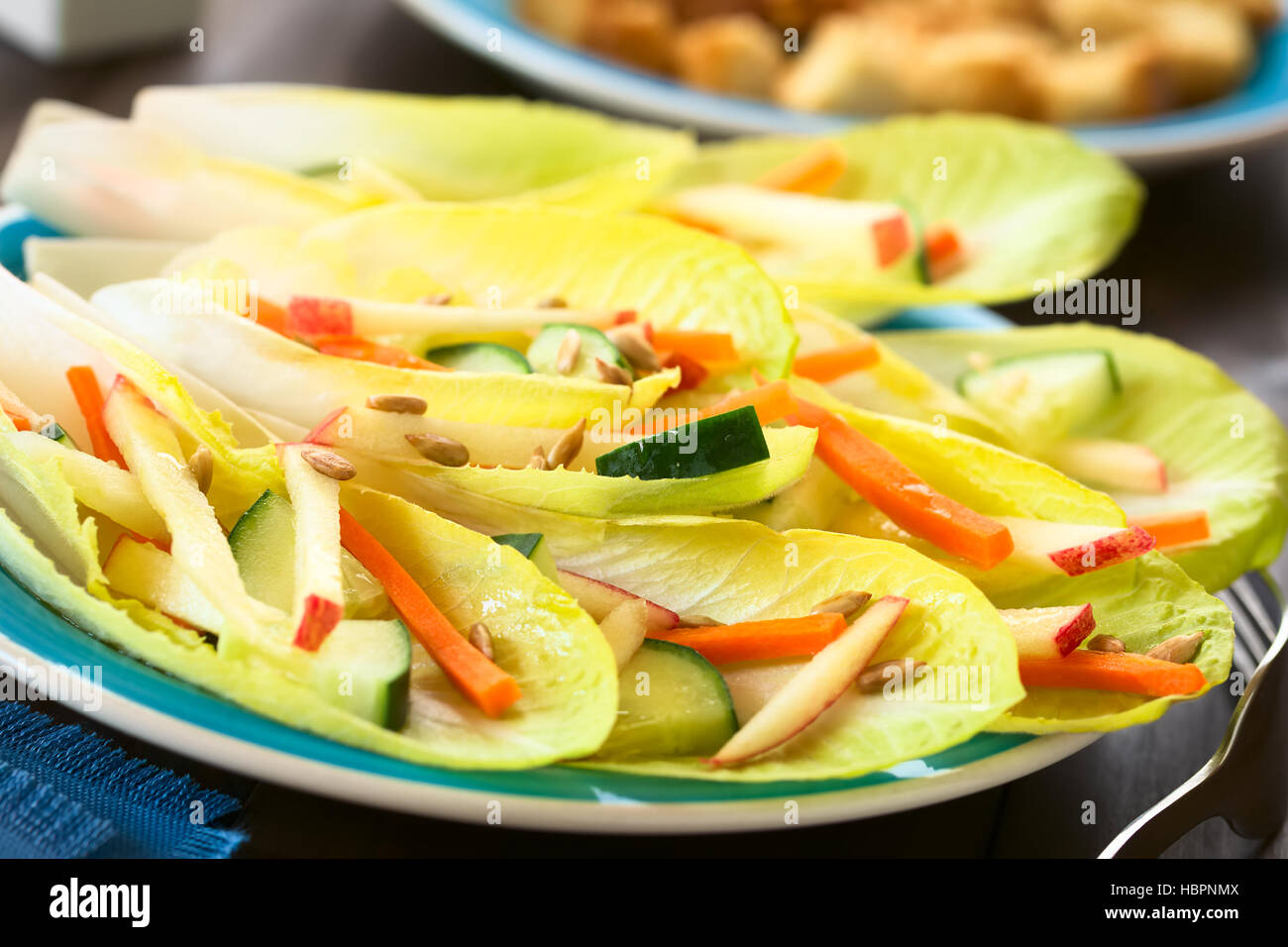 Salade fraîche de feuilles d'endive, concombre, carotte, pomme et graines de tournesol, photographié avec une lumière naturelle (Selective Focus) Banque D'Images