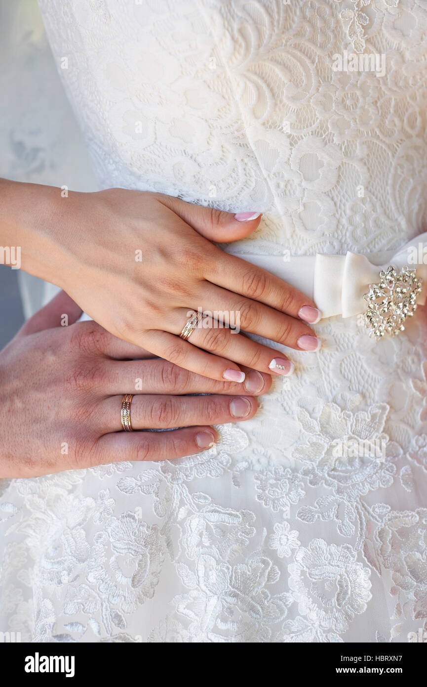 Mains de la mariée et le marié avec joints toriques sur brides dress Banque D'Images