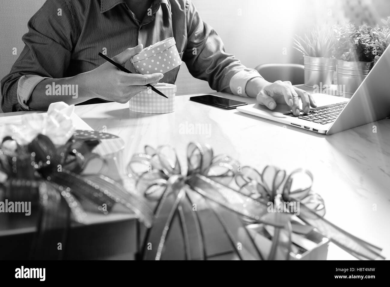 Donner de cadeau main créatrice le choix et la main avec don. Livraison de cadeaux, surprise,latop ordinateur et téléphone intelligent sur mable 24,black white Banque D'Images