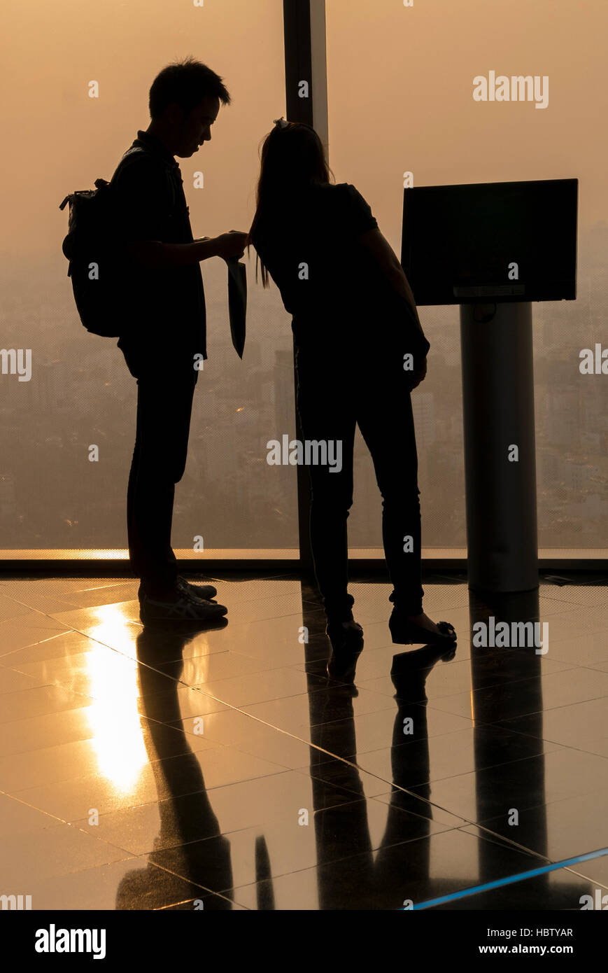 Silhouettes observant le couple vue aérienne pendant le coucher du soleil à Saigon Banque D'Images