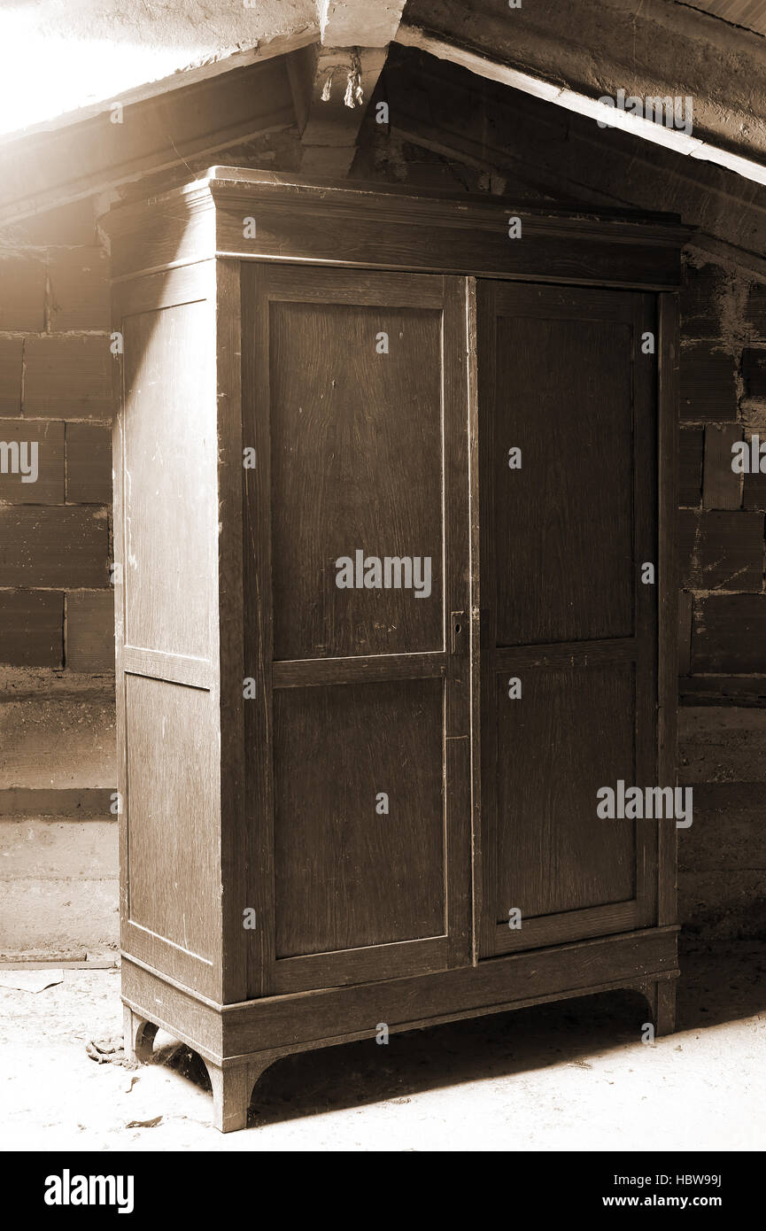 Ancienne armoire en bois poussiéreux dans un grenier de la maison Banque D'Images