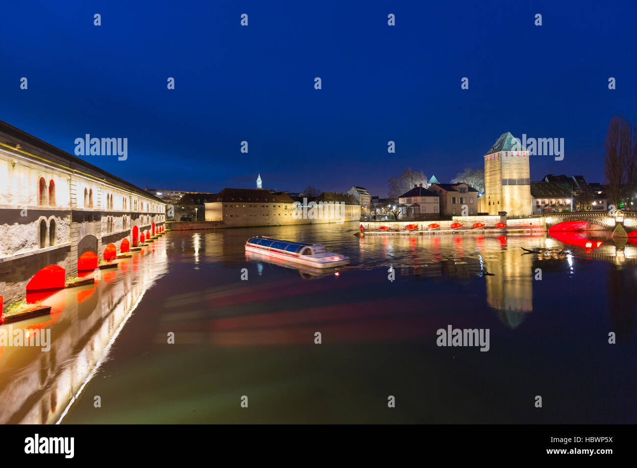 Bateau d'excursion avec les touristes en face du Barrage Vauban et Ponts Couverts dans la nuit le long de la rivière Ill Strasbourg, Alsace, France Banque D'Images