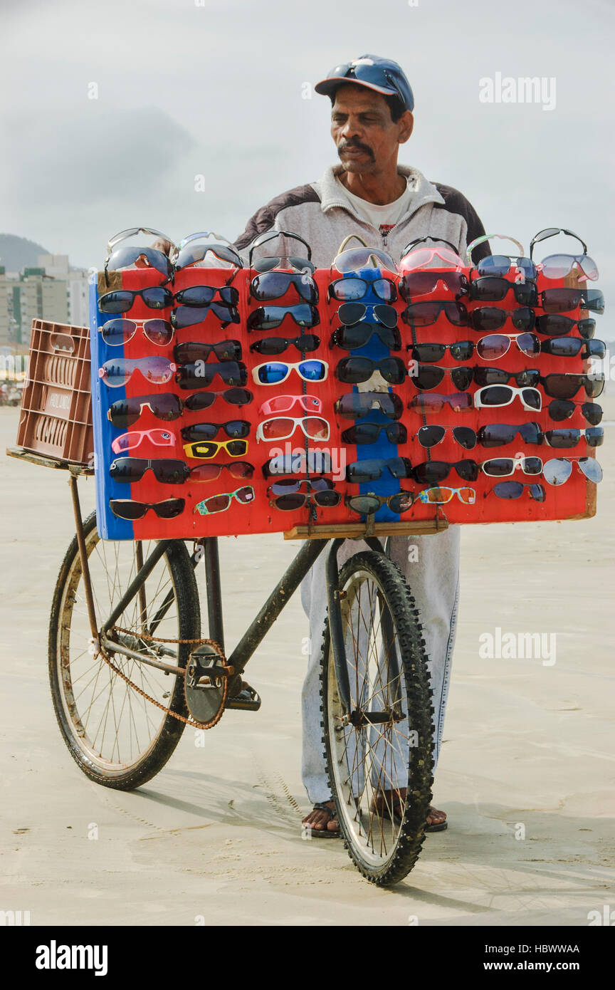 Peuple du Brésil, homme vendant des lunettes de soleil à Praia Grande Beach dans l'état de Sao Paulo, Brésil. Banque D'Images