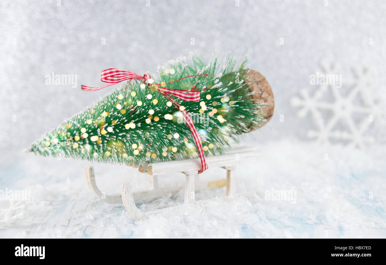 Petit jouet traîneau transportant un arbre de Noël Banque D'Images