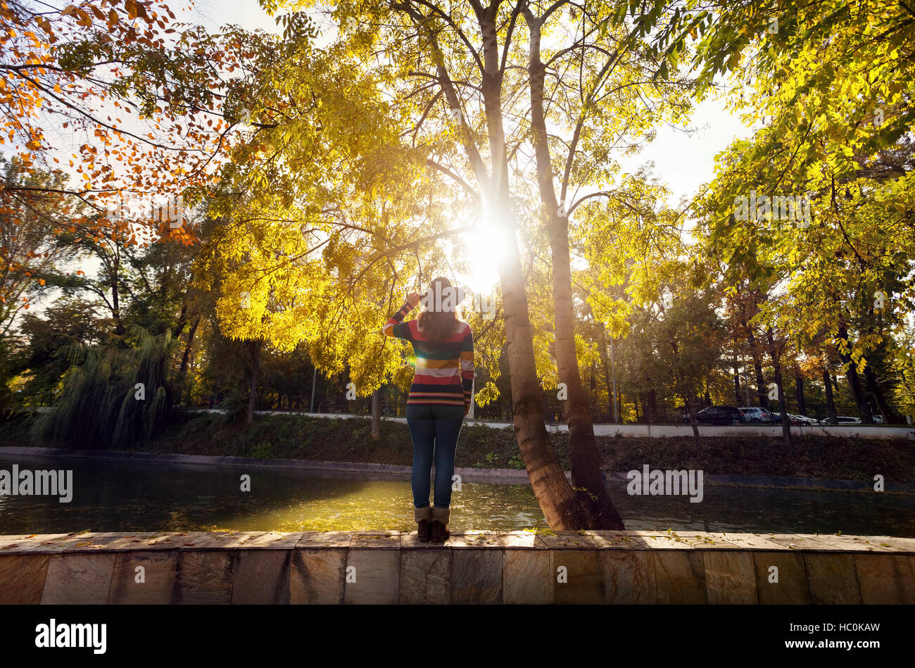 Woman with hat près de l'arbre avec l'automne jaune arbres du parc Banque D'Images