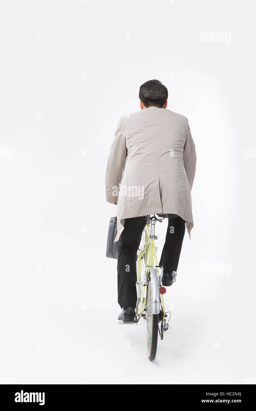 Retour de middle aged businessman riding a bicycle Banque D'Images