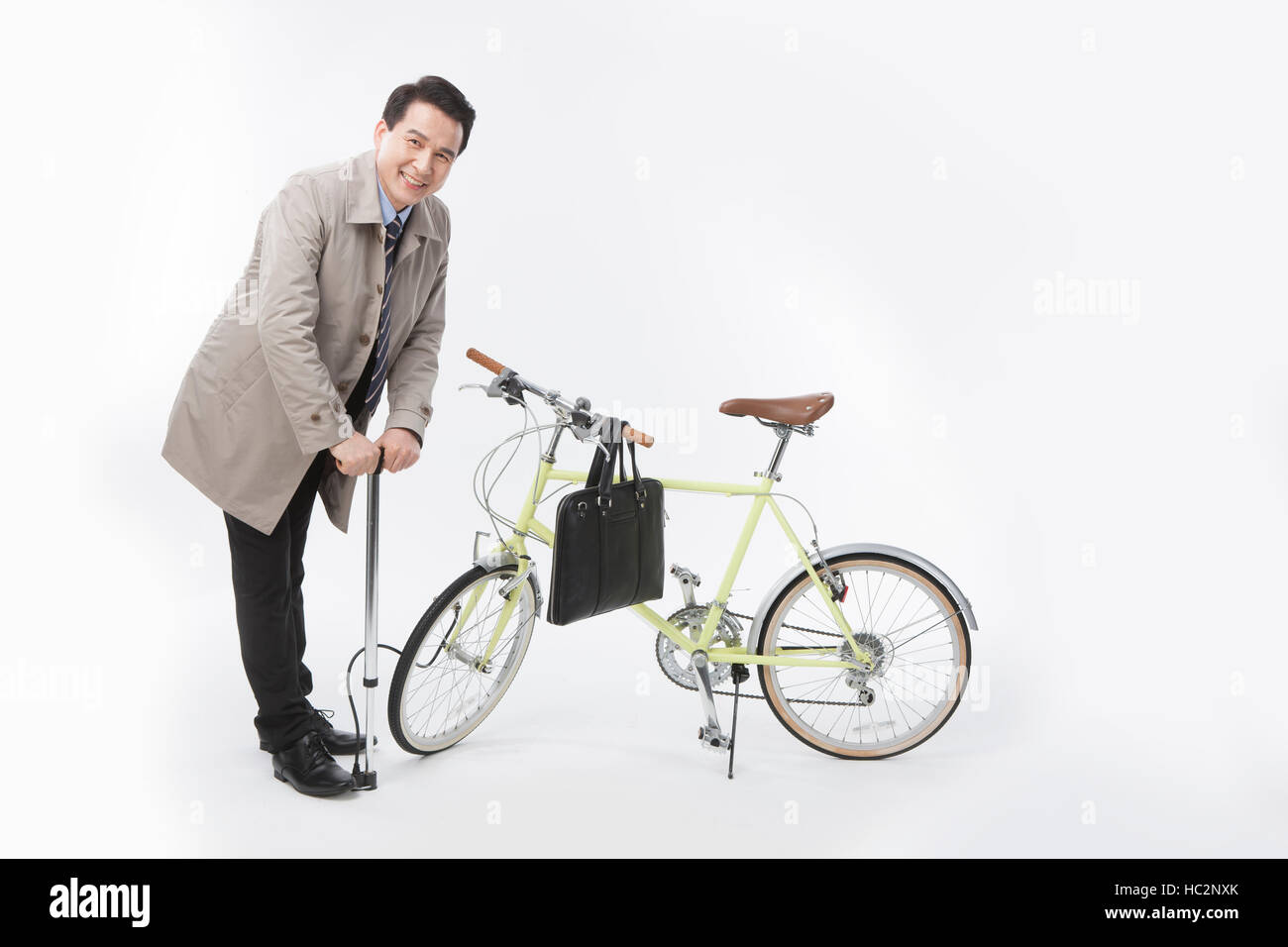 Smiling middle aged businessman en pompant son vélo Banque D'Images