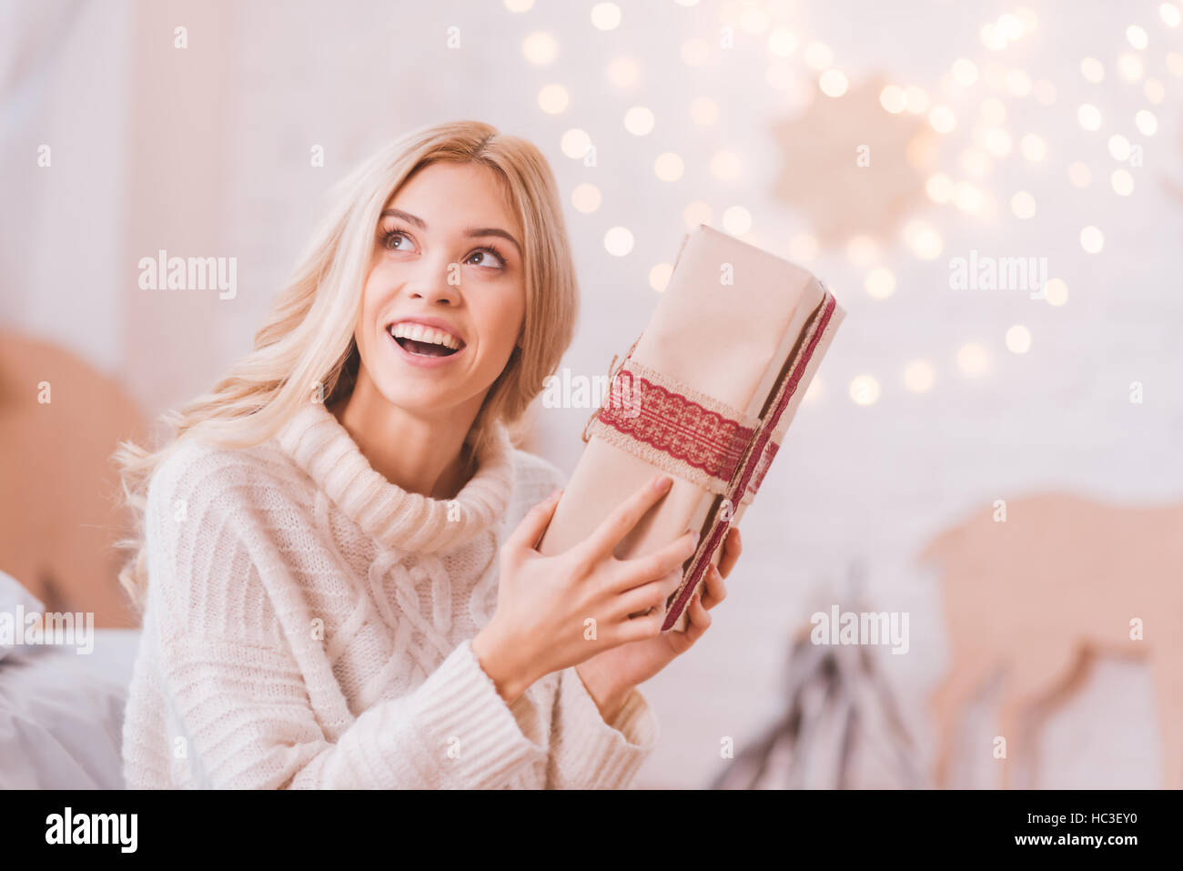 Cheerful woman curieux une boîte de Noël Banque D'Images