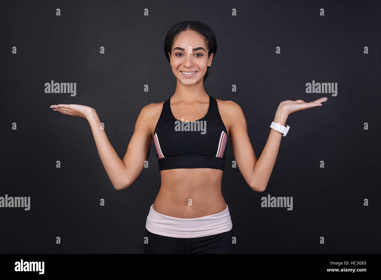 Jeune belle brunette posing with hands up Banque D'Images