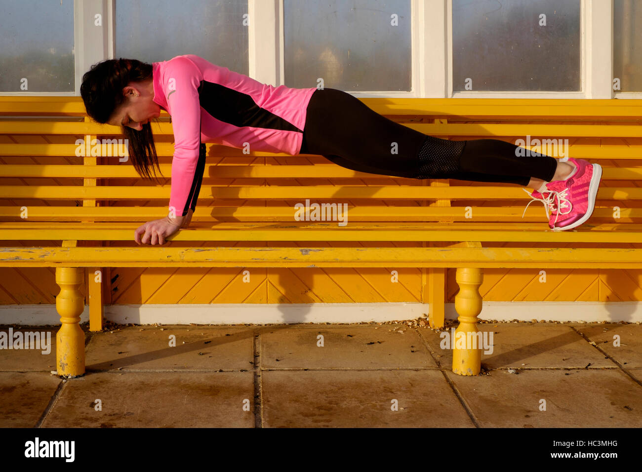 Une jeune femme exerçant au cours de sa routine quotidienne de se tenir en forme en plein air england uk Banque D'Images