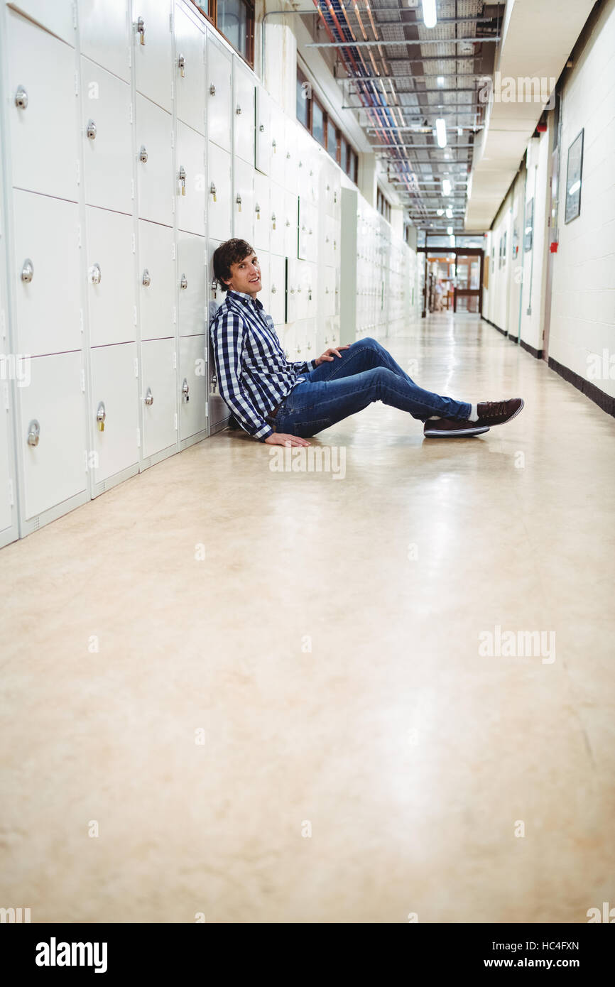 Student sitting in locker room Banque D'Images
