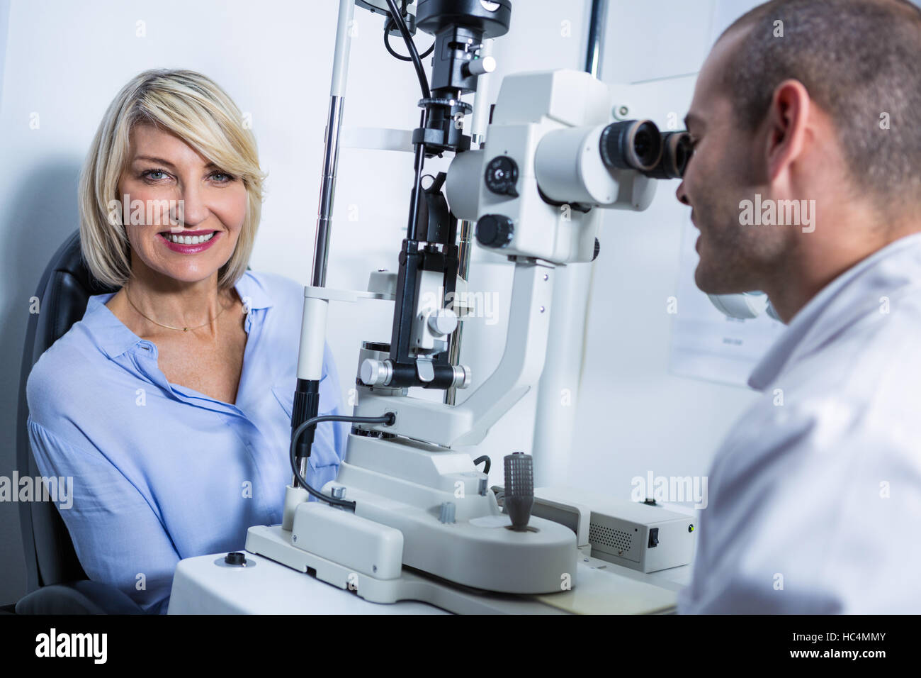 Optométriste examinant female patient sur lampe à fente Banque D'Images