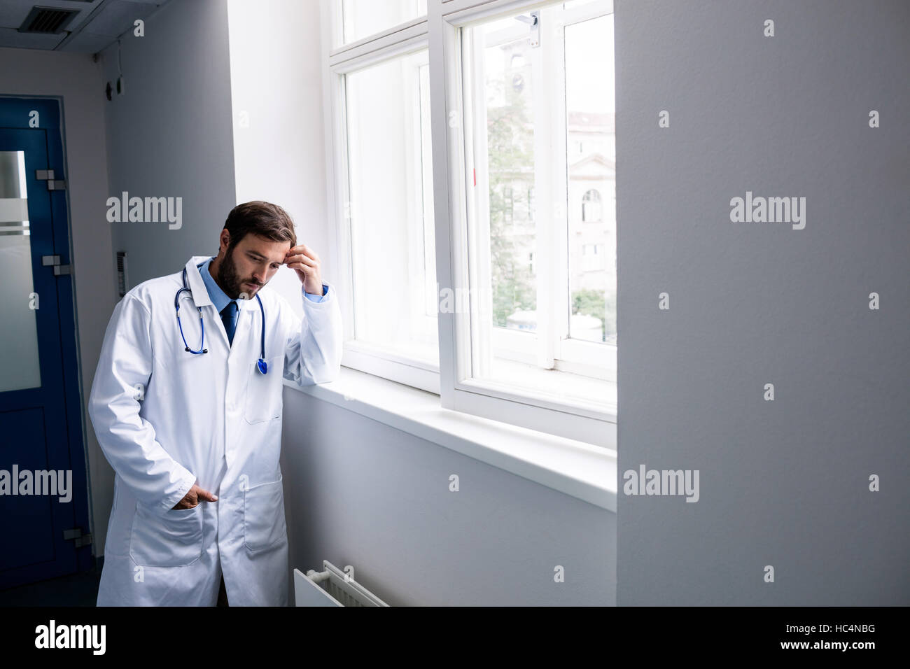 Triste doctor standing in corridor Banque D'Images