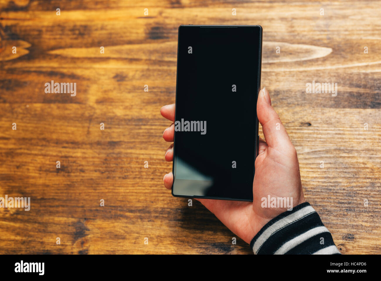 Le paiement mobile et les services bancaires électroniques, femme la main avec nouveau smartphone élégant noir et blanc de l'écran comme copy space Banque D'Images