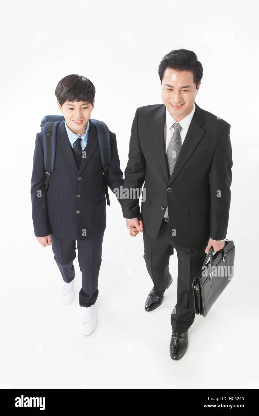 Portrait of smiling businessman et son middle school student fils marche main dans la main Banque D'Images