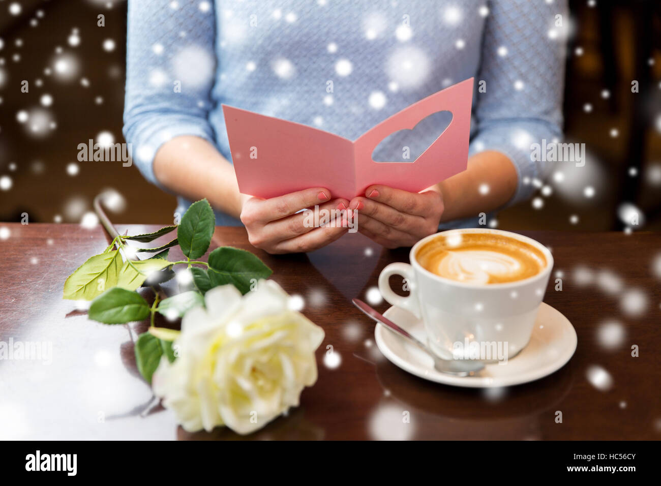 Femme avec fleurs et café lecture carte de souhaits Banque D'Images