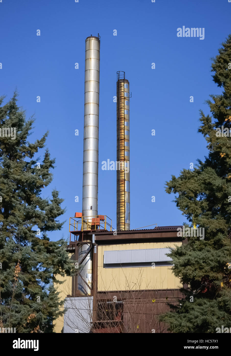 Deux hautes cheminées métalliques comme un polluant dans un établissement urbain Banque D'Images