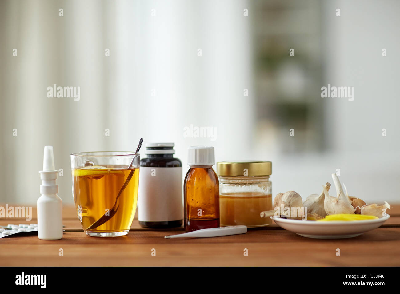 La drogue, thermomètre, le miel et une tasse de thé sur bois Banque D'Images