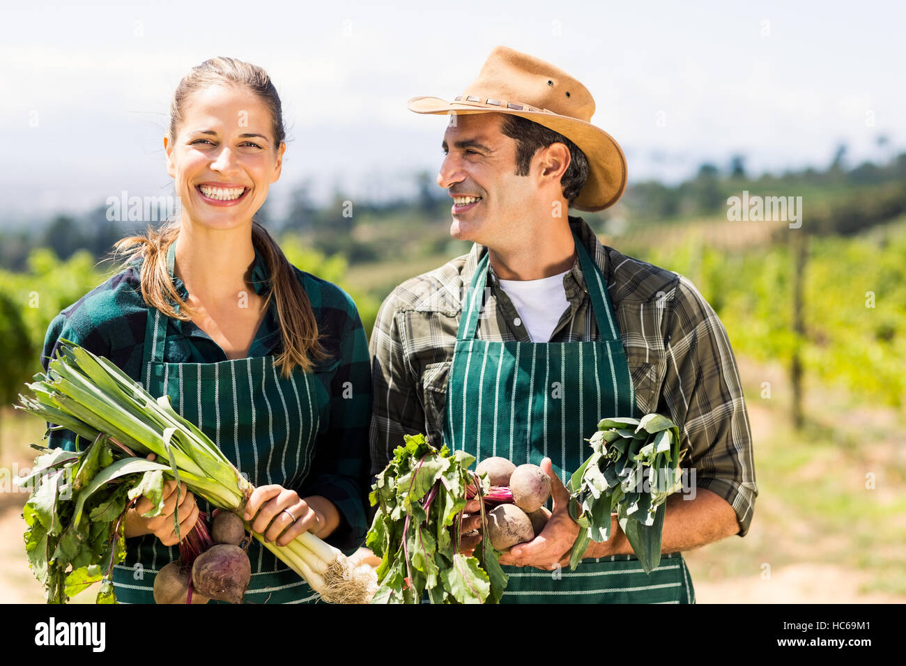 Happy Farmer couple holding légumes feuilles Banque D'Images