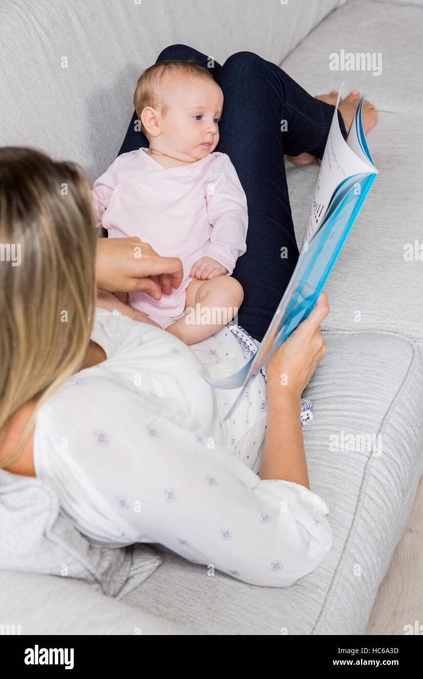 Livre d'histoire montrant la mère à son bébé dans la salle de séjour Banque D'Images