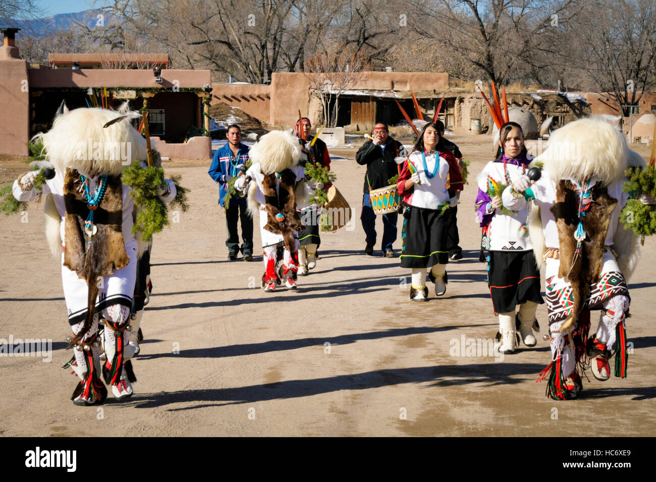Les hommes et les femmes aux coiffes de buffle blanc exécutent des danses traditionnelles de buffle avec des batteurs en arrière-plan à Ohkay Owingeh Pueblo, Nouveau-Mexique Banque D'Images