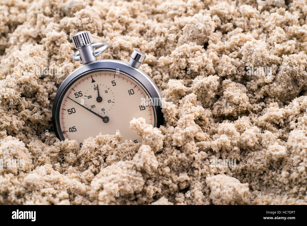 Chronomètre à demi-enterré dans le sable Banque D'Images