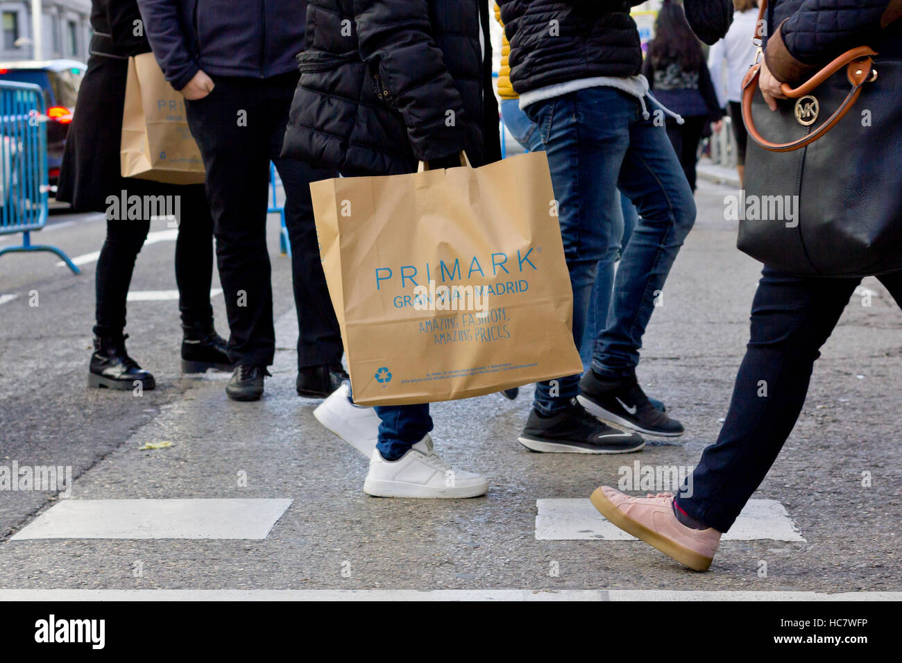 Gens portant des sacs Primark traversant la rue Gran Via (Madrid, Espagne). Banque D'Images