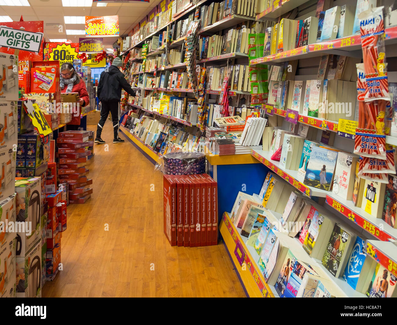 Jeune homme shopping de Noël dans un magasin de livres à prix réduits Banque D'Images