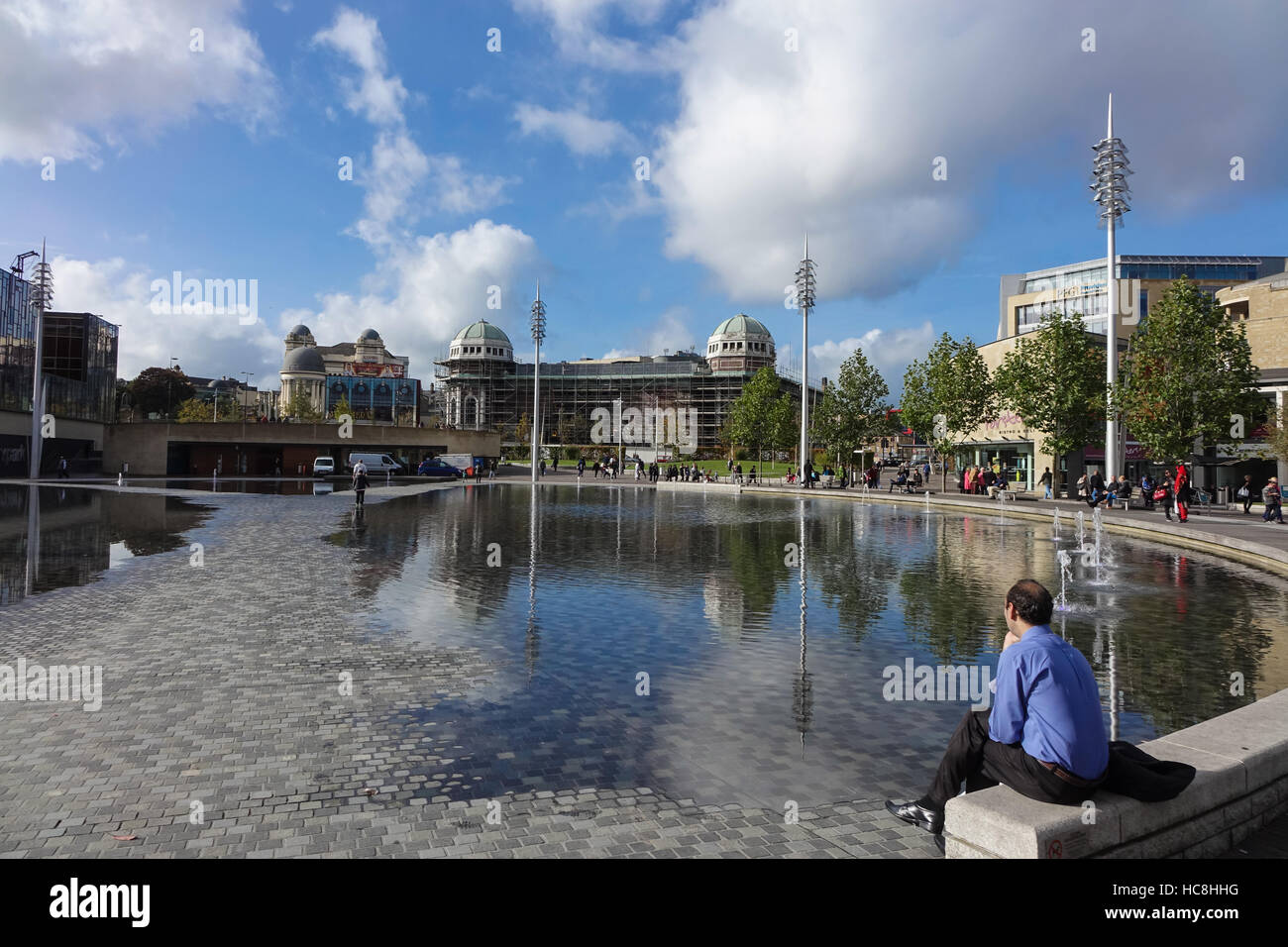 L'homme assis près de la piscine miroir à Bradford Banque D'Images
